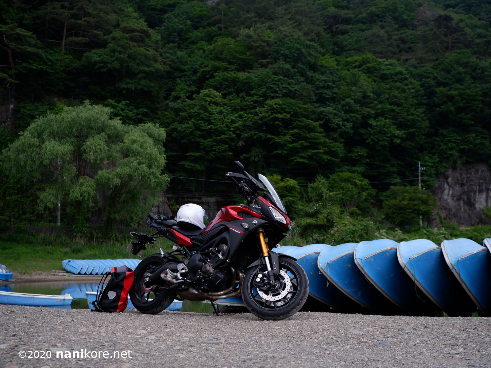 Lake Saiko with the motorcycle in front of some boats